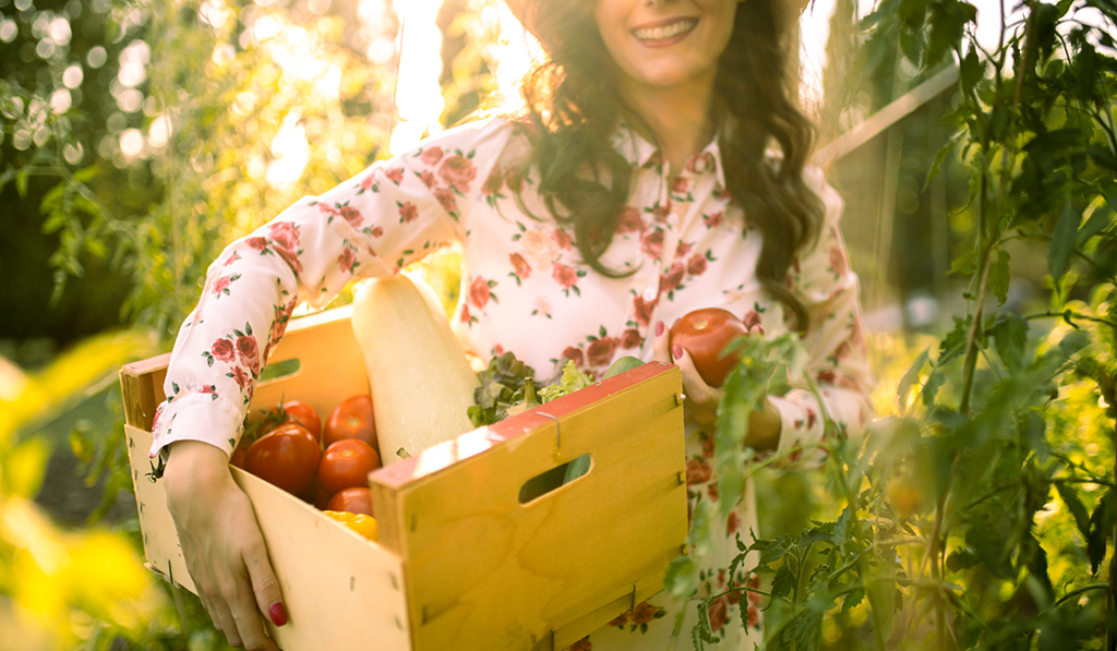 woman holding box of tomatoes